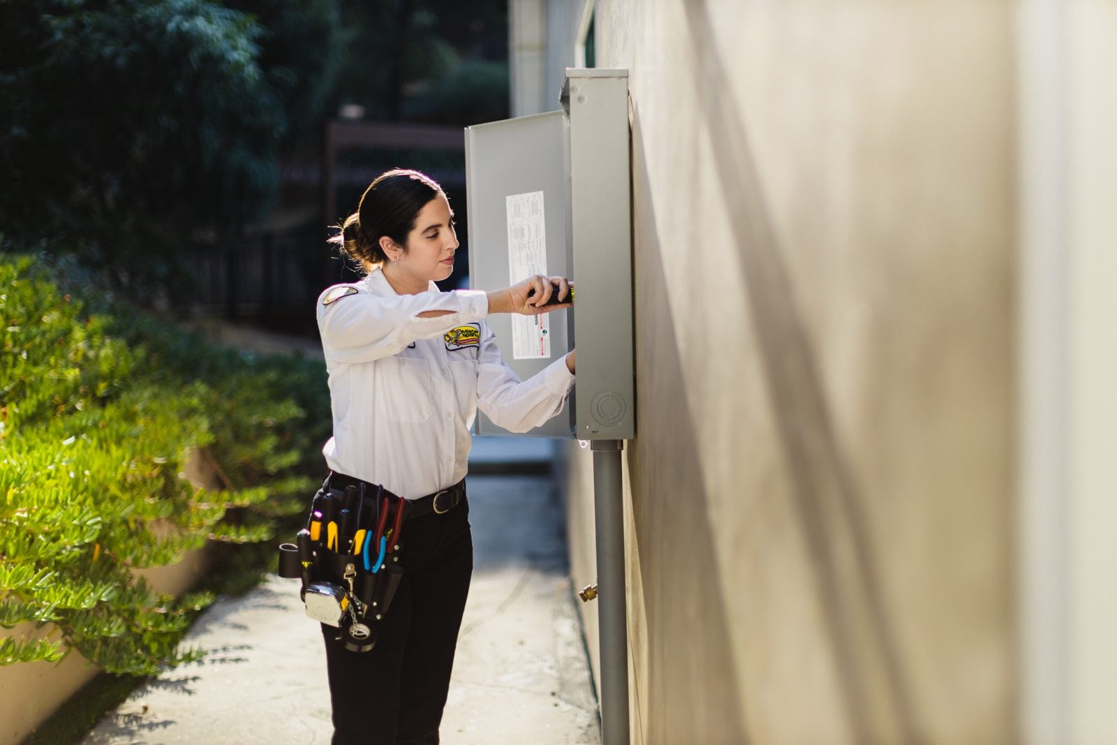Licensed electrician inspecting an older home fuse box